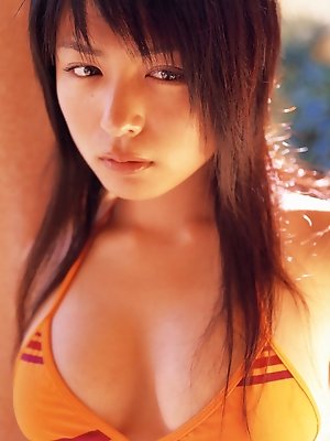 Petite cute little asian gravure model wearing an orange bikini