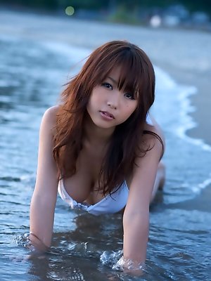 Busty asian beauty posing in a skimpy bikini at the beach